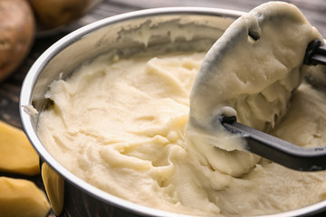 Kitchen utensil and mashed potatoes in cookware, closeup