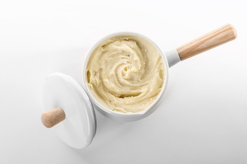 Cookware with mashed potatoes on white background