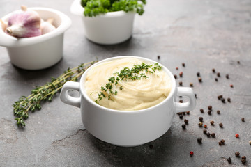 Dish with mashed potatoes on grey background