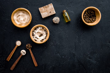 Aromatic spa cosmetics. Chocolate brown spa salt on black background top view copy space