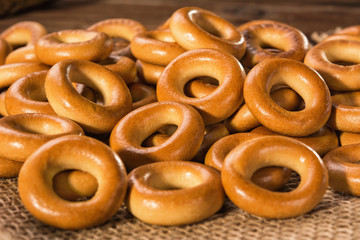 Small dry bagels on a wooden table, view from the side.