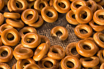 Small dry bagels on wooden table, top view.