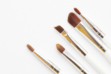 Make Up Beauty Concept. Set of make up brushes for lipstick, eyeshadows, foundation, powder, eyeliner and blusher on white background with copy space, top view, flat lay