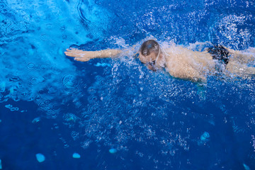 Fototapeta na wymiar Male swimmer at the swimming pool. Underwater photo. Male swimmer.