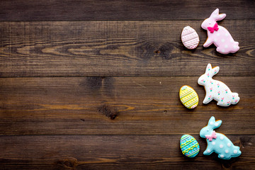 Easter bunny and easter eggs cookies. Easter symbols and traditions. Dark wooden background top...