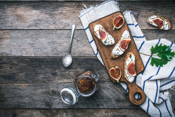 tasty Snacks with cheese jam and figs on wood