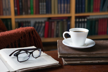 Sweet moments of relaxation with books and a cup of coffee. Vintage books, glasses, chair, library