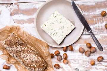cheese with dill and bread huzelnuts on wooden board