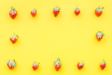 Fresh ripe strawberry. Pattern on yellow pastel background top view copy space