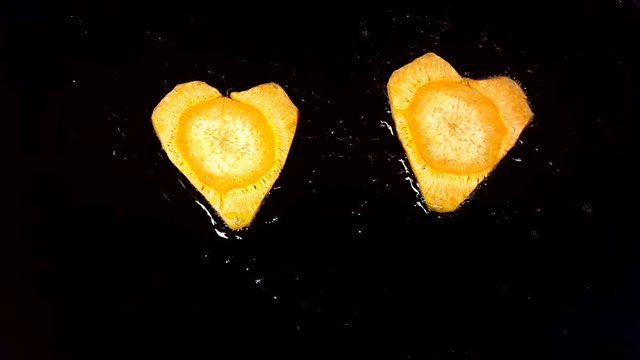 Fry carrots in the shape of heart in a frying pan
