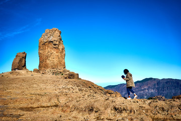 Naklejka premium Woman hiking on trail to Roque Nublo - Gran Canaria - Tejeda - Blue sky over Canary Islands