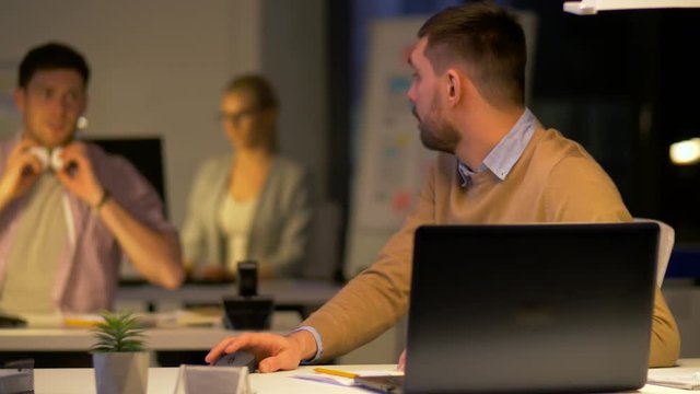 office worker with laptop asks colleague for help