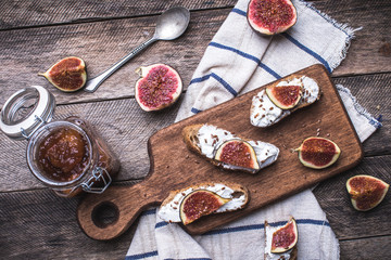 Bruschetta snacks with jam and figs on napkin in rustic style