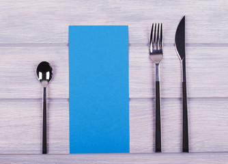 Empty blue paper between covered kitchen on wooden table. Menu. Food