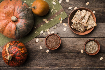 Rustic style autumn pumpkins with cookies and seeds on wood