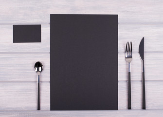 Empty black paper between covered kitchen on wooden table. Menu. Food