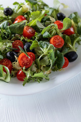Green salad with tomatoes and black olives.