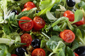 Green salad with tomatoes and black olives.
