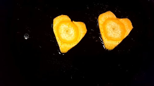 Fry carrots in the shape of heart in a frying pan