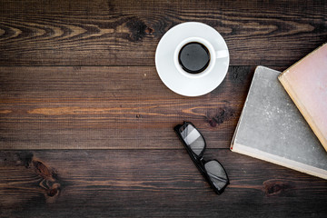 Reading books as hobby. Books, coffee and glasses on dark wooden background top view copy space