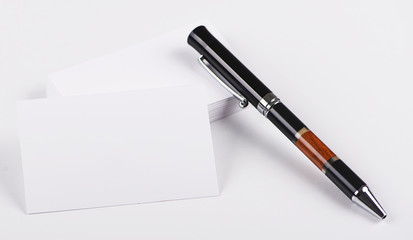 Business cards next to black pen on white background. Isolated. Mockup.
