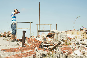 Man observing the destruction of his home.