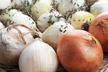 Pile of fresh onions with thyme, closeup