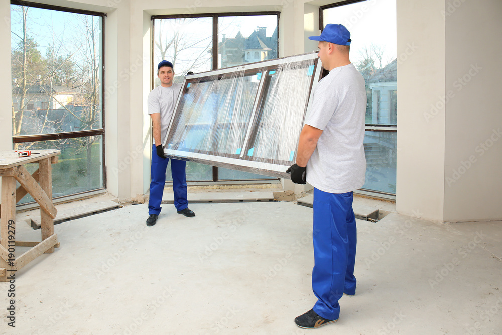 Wall mural construction workers carrying window glass indoors