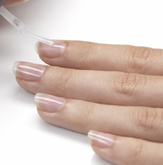 applying transparent nail polish on nails