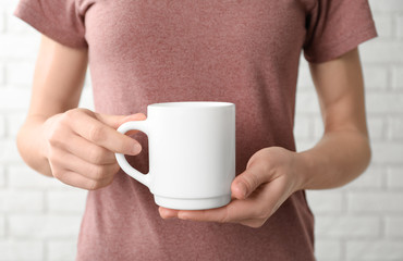 Woman holding ceramic cup, closeup. Mockup for design