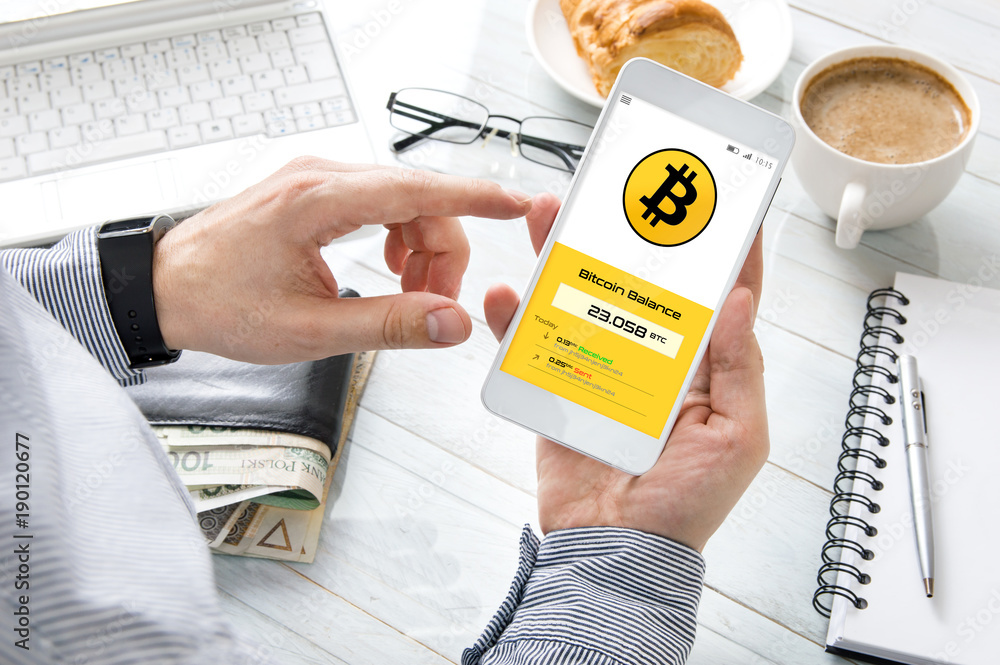 Fototapete man checks bitcoin rate at his cryptocurrency wallet. smartphone application was created in graphic 