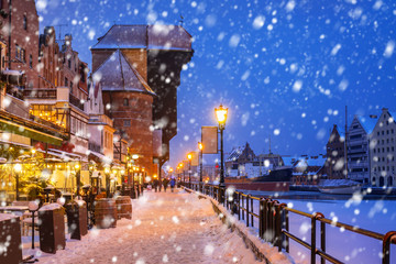 Historic crane in the old town of Gdansk on a cold winter night with falling snow, Poland