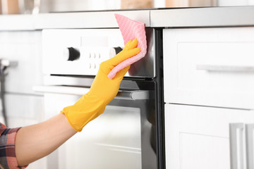 Man cleaning oven in kitchen, closeup