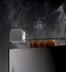 Toaster toasting a bread slice with smoke on gray