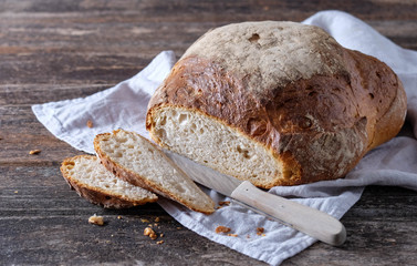 Frisch angeschnittenes rundes Landbrot auf Holztisch