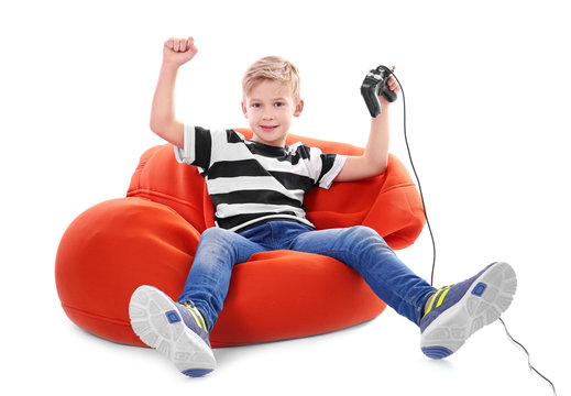 Happy boy with video game controller on white background