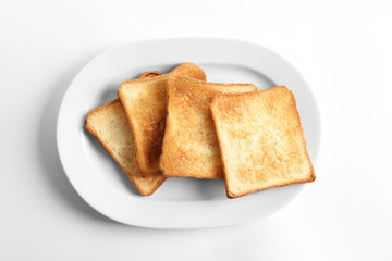 Plate with toasted bread on white background