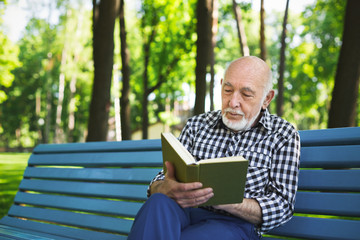 Fototapeta premium Elderly man in casual reading outdoors