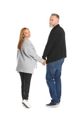 Mature couple in casual clothes walking on white background