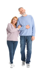 Mature couple in casual clothes walking on white background