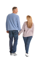 Mature couple in casual clothes walking on white background