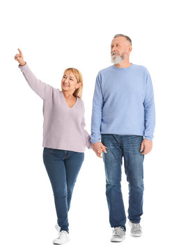 Mature Couple In Casual Clothes Walking On White Background