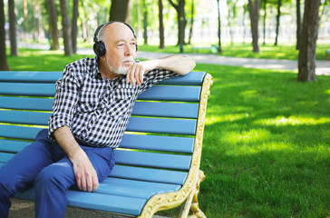 Fototapeta premium Pensive senior man in earphones outdoors