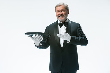 Senior waiter holding tray