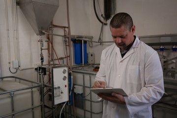 Male worker writing on clipboard