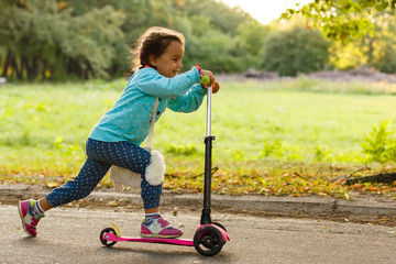 Mother Teaching Daughter To Ride Scooter