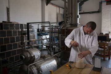 Worker checking quality of gin