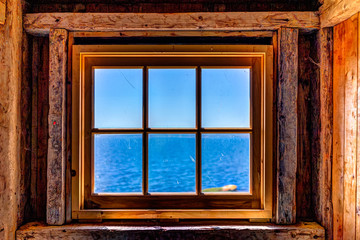 Looking through old rustic window of house with ocean view in Bonaventure Island, Quebec, Canada