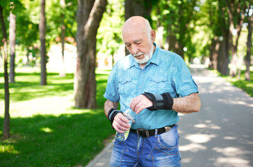 Naklejka na ściany i meble Senior man in casual wear with water bottle