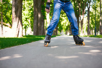 Naklejka premium Male legs in jeans and roller skates